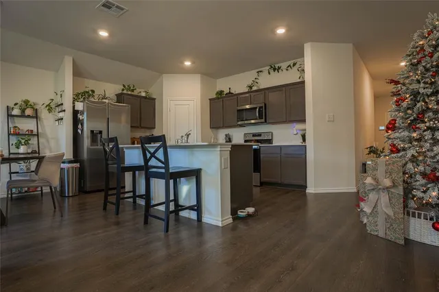 a kitchen with stainless steel appliances a refrigerator and a stove top oven