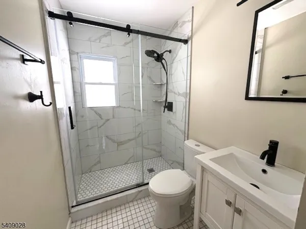 a bathroom with a shower a toilet and a sink