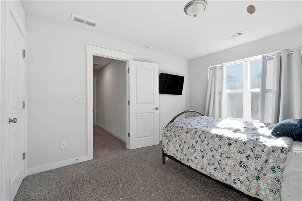 4806 Anvil Court Jefferson, GA 30549 - Photo 17 of 31 a bedroom with a bed and a flat tv screen on the dresser