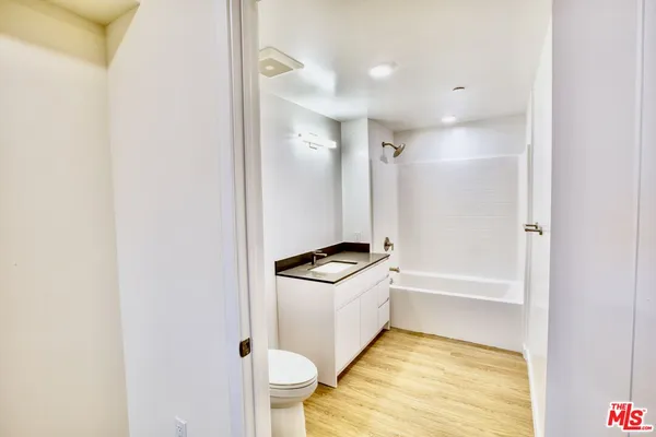 a bathroom with a tub sink vanity and toilet