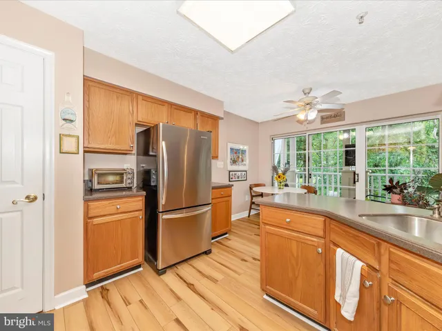 a kitchen with granite countertop a stove top oven a sink dishwasher and a fireplace with wooden floor