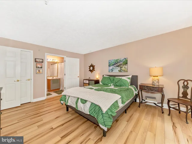 a spacious bedroom with a bed and a flat screen tv