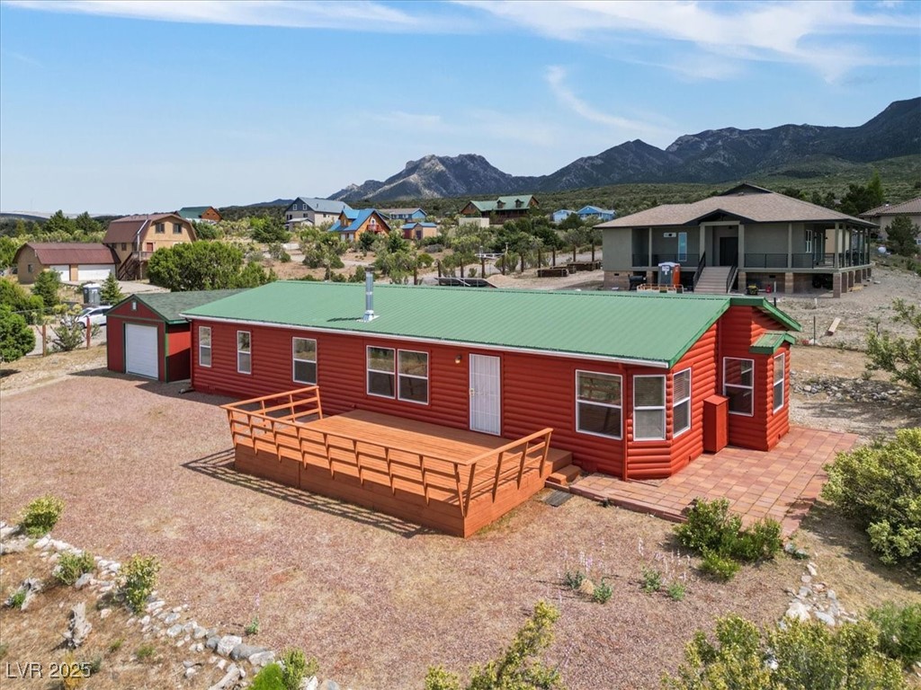 70 West Bonanza Road Las Vegas, NV 89124 - Photo 55 of 71 Rear view of property with faux log siding, a deck with mountain view, a detached garage, and a residential view