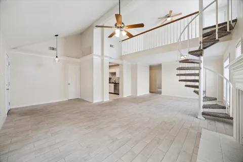 a view of a hallway with stairs and a chandelier