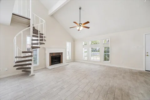 a view of an empty room with a fireplace and a window