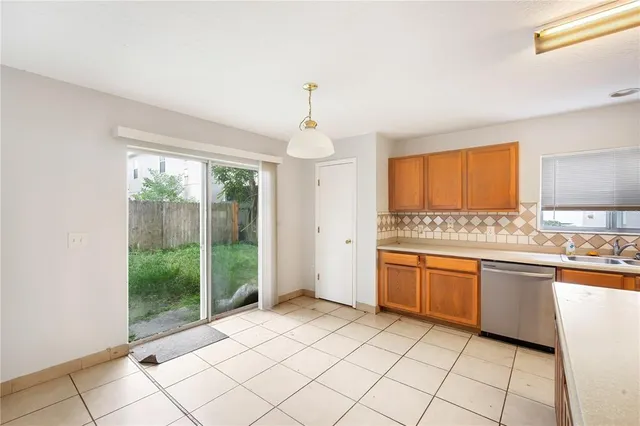 a large kitchen with granite countertop a stove a sink dishwasher and a refrigerator