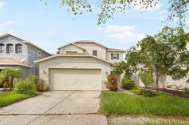 a front view of a house with a yard and garage