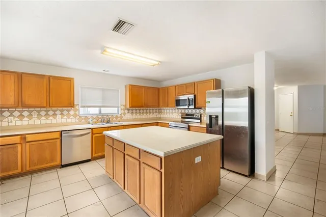 a kitchen with stainless steel appliances granite countertop a stove a sink dishwasher and a refrigerator