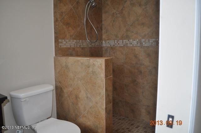 1711 Derringer Road Jacksonville, FL 32225 - Photo 16 of 25 a white toilet sitting next to a shower curtain