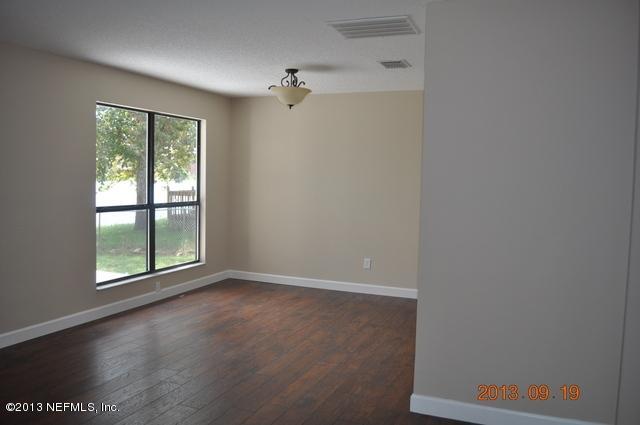 1711 Derringer Road Jacksonville, FL 32225 - Photo 5 of 25 an empty room with wooden floor and windows