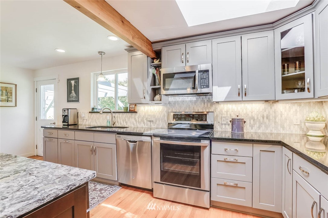 3522 Northeast 10th Place Renton, WA 98056 - Photo 4 of 34 a kitchen with stainless steel appliances granite countertop a stove a sink and a microwave
