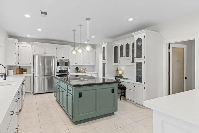 a kitchen with white cabinets and stainless steel appliances