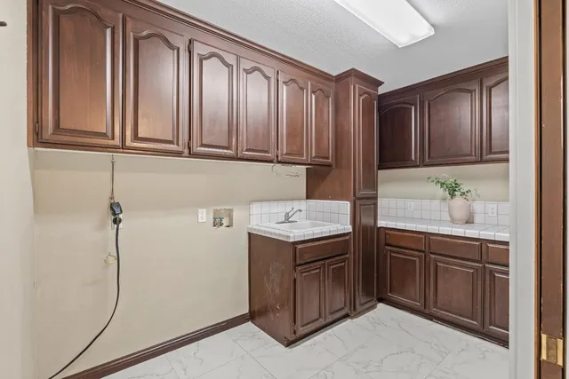a bathroom with a granite countertop sink a mirror and shower