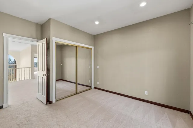 a view of an empty room with closet and wooden floor