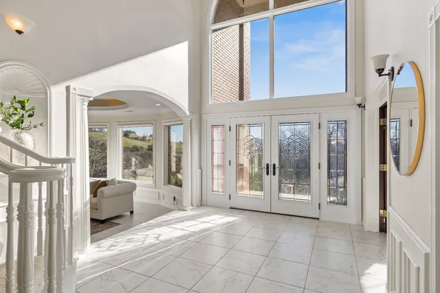 a living room with furniture a dining table and a chandelier