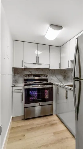a kitchen with granite countertop a stove and a refrigerator