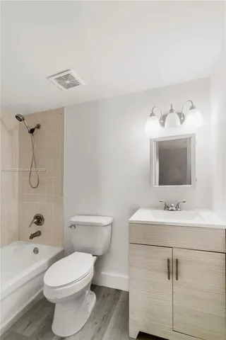 a bathroom with a sink toilet vanity and shower