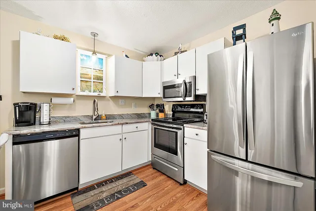a kitchen with stainless steel appliances a refrigerator sink and microwave