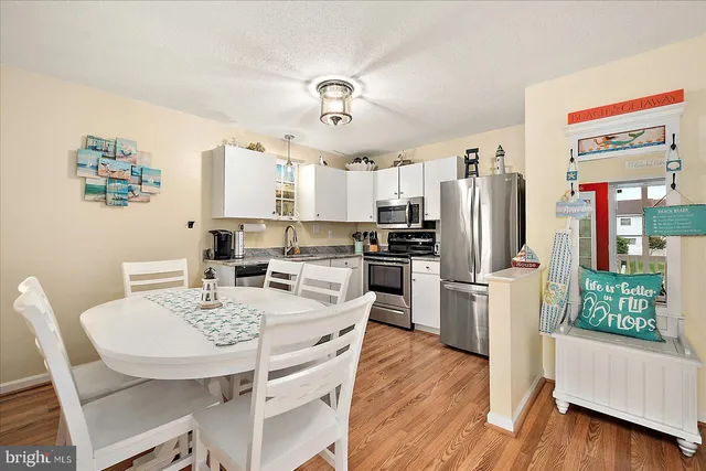a kitchen with stainless steel appliances a dining table and chairs