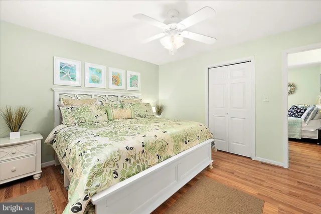 a large bed sitting in a bedroom next to a window and a chandelier