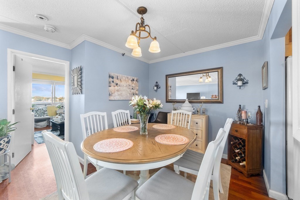 100 Cove Way, Unit 608 Quincy, MA 02169 - Photo 13 of 26 a dining room with furniture a chandelier and wooden floor