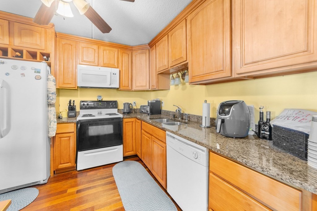 100 Cove Way, Unit 608 Quincy, MA 02169 - Photo 9 of 26 a kitchen with granite countertop a sink a counter top space stainless steel appliances and cabinets