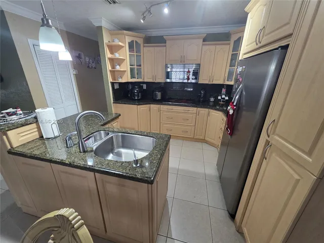 a kitchen with granite countertop a sink and a refrigerator