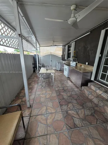 a outdoor space with lots of white furniture and a rug