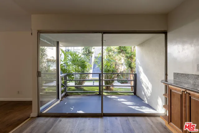 a view of a room with wooden floor and door