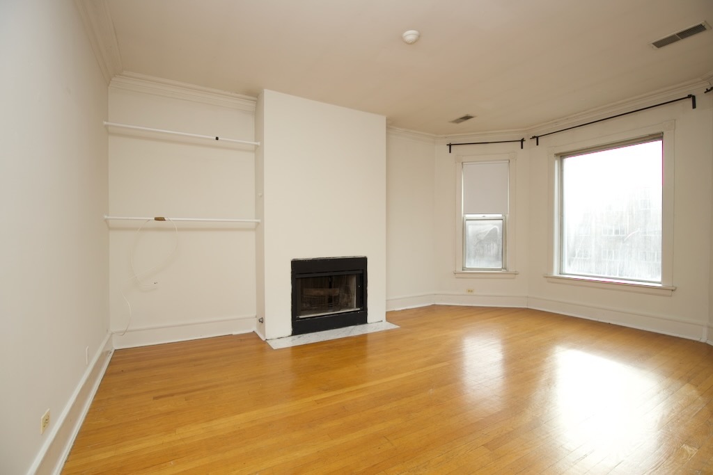 6717 North Sheridan Road, Unit 3S Chicago, IL 60626 - Photo 9 of 20 a view of empty room with wooden floor and fireplace