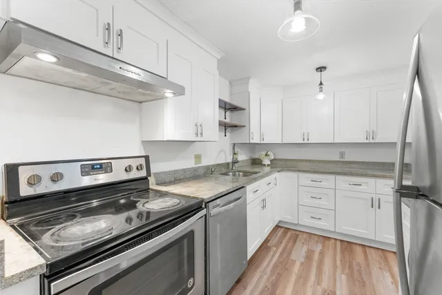 a kitchen with a stove oven and white cabinets