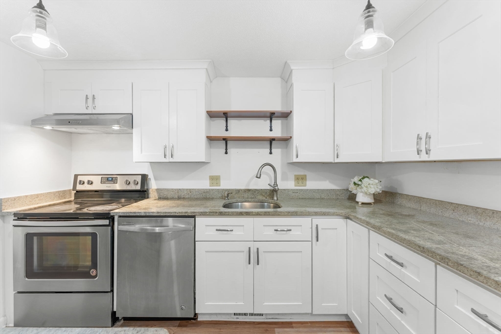 5 Elm Street, Unit 1 Acton, MA 01720 - Photo 12 of 30 a kitchen with granite countertop cabinets stainless steel appliances and a sink