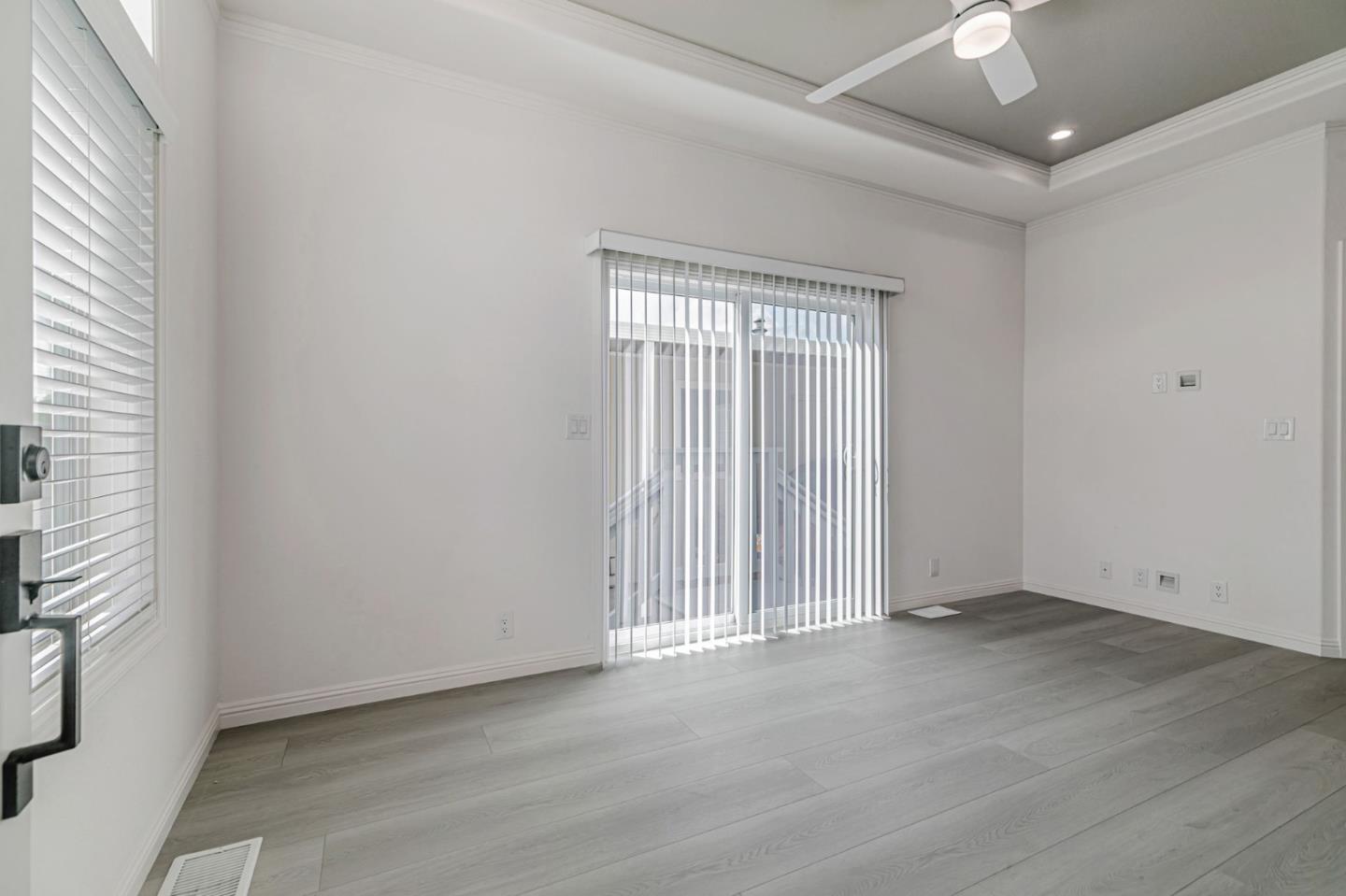 555 Umbarger Road, Unit 131 San Jose, CA 95111 - Photo 5 of 32 an empty room with wooden floor and windows with curtains