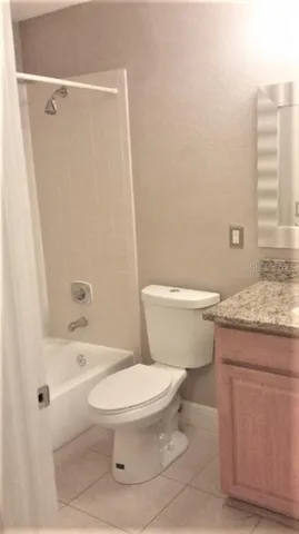 a bathroom with a granite countertop toilet a sink and a bathtub