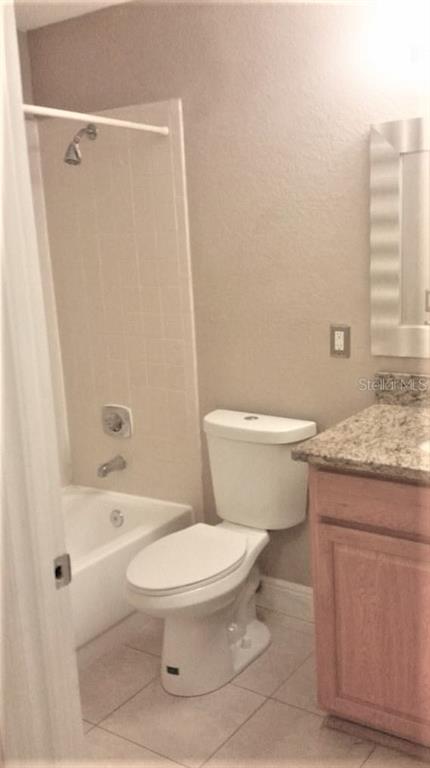 1049 South Hiawassee Road, Unit 3416 Orlando, FL 32835 - Photo 12 of 22 a bathroom with a granite countertop toilet a sink and a bathtub