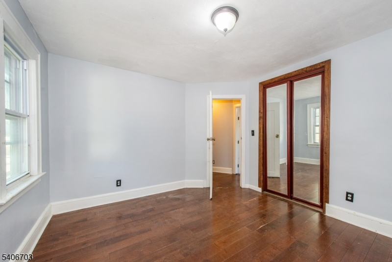 86 Watsessing Avenue, Unit 1 Bloomfield, NJ 07003 - Photo 14 of 21 an empty room with wooden floor and windows
