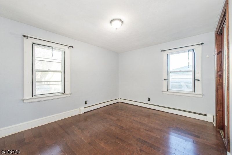 86 Watsessing Avenue, Unit 1 Bloomfield, NJ 07003 - Photo 15 of 21 an empty room with wooden floor and windows