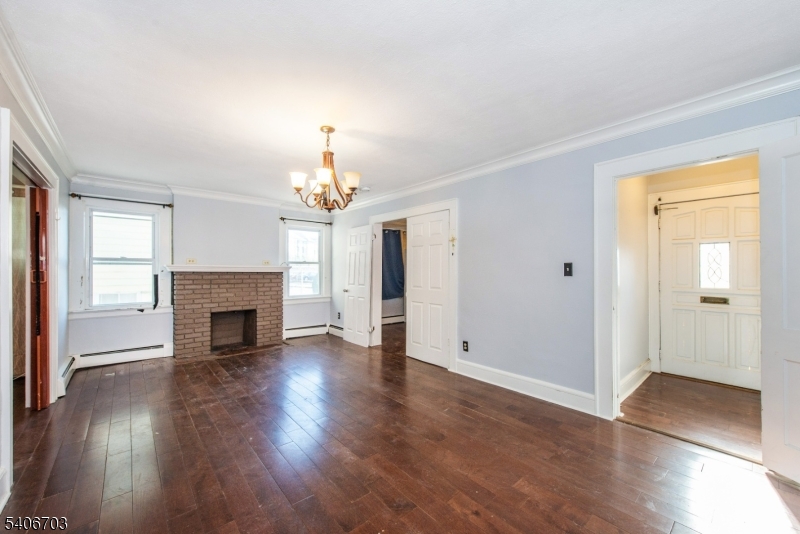 86 Watsessing Avenue, Unit 1 Bloomfield, NJ 07003 - Photo 7 of 21 an empty room with wooden floor fireplace and windows