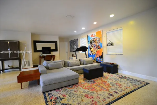 a living room with furniture and kitchen view