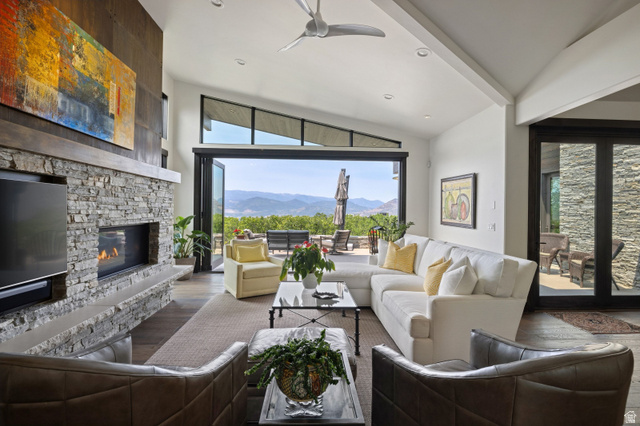 11547 Soaring Hawk Lane Hideout, UT 84036 - Photo 1 of 43 Spacious living area featuring a stacked stone fireplace with a built-in media center, vaulted ceilings, and large bi-fold glass doors opening to the exterior