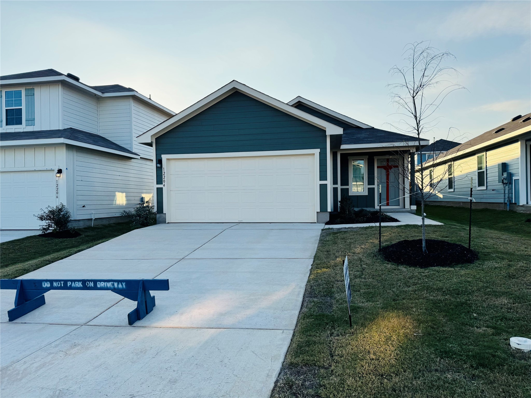 12204 Douglas Fir Circle Mustang Ridge, TX 78610 - Photo 1 of 17 a view of a white house with a yard and potted plants