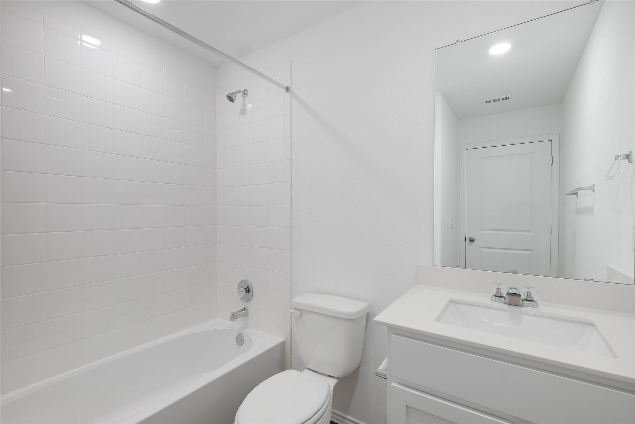 12204 Douglas Fir Circle Mustang Ridge, TX 78610 - Photo 16 of 17 a bathroom with a toilet sink vanity mirror and bathtub
