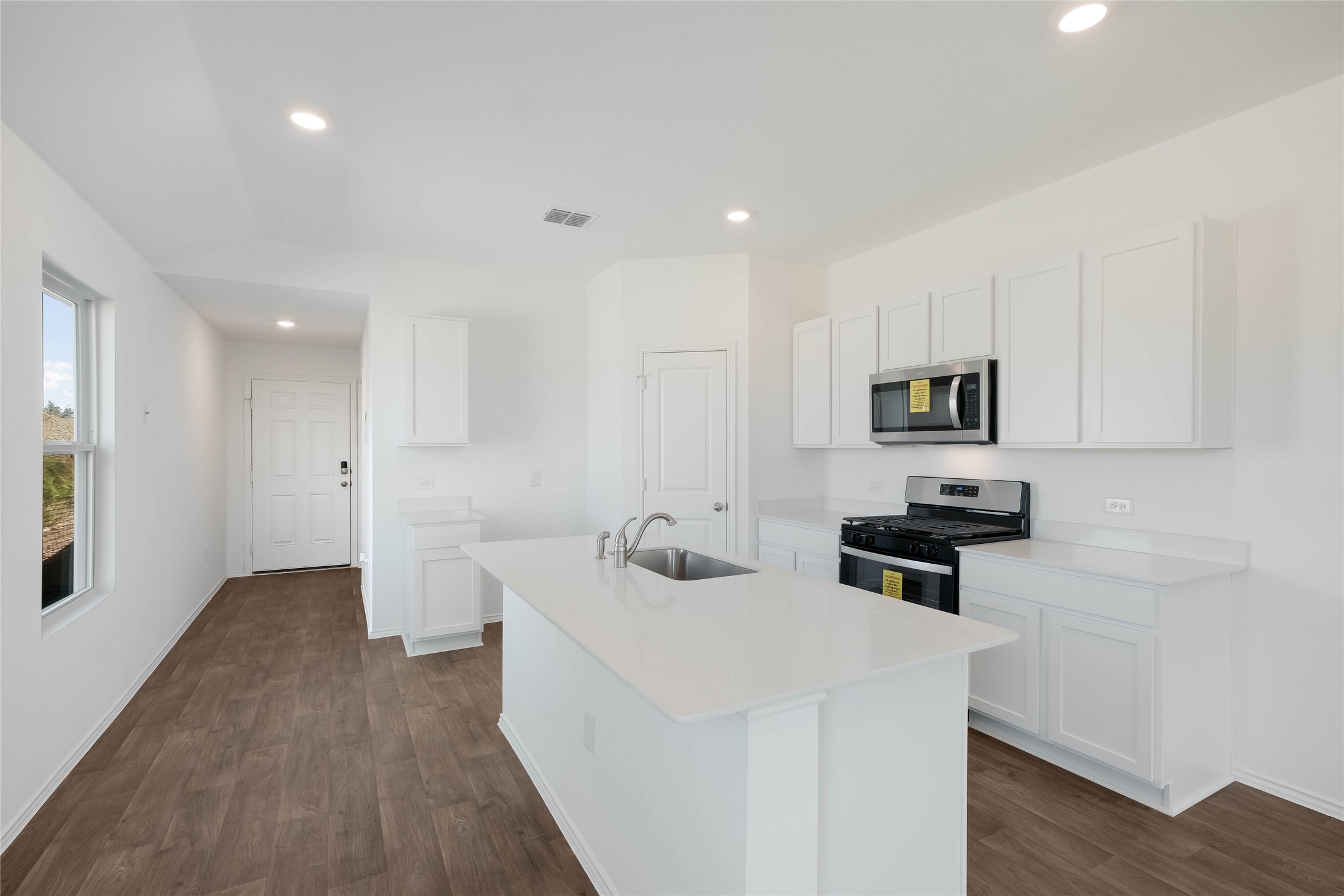 12204 Douglas Fir Circle Mustang Ridge, TX 78610 - Photo 6 of 17 a kitchen with white cabinets and appliances