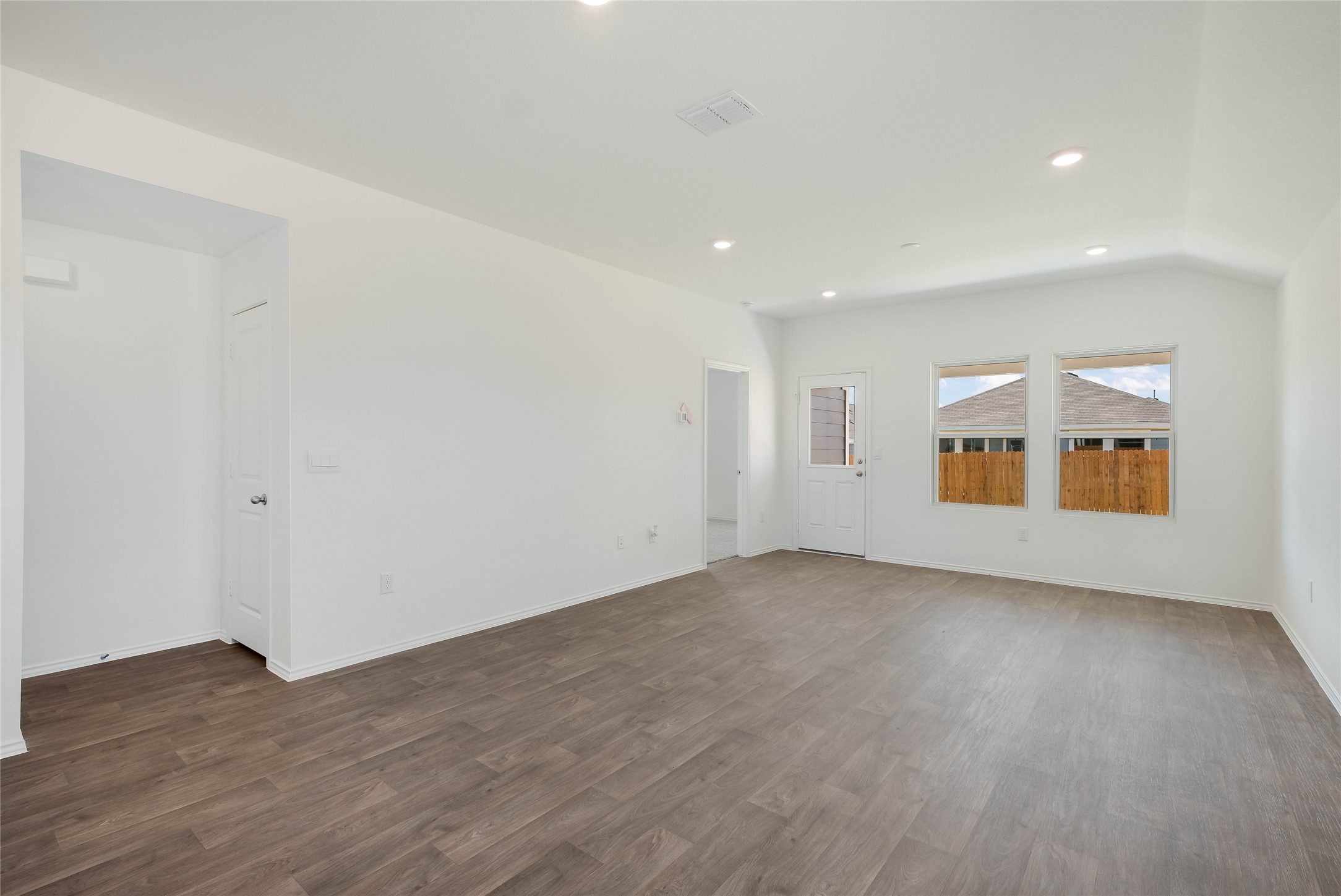 12204 Douglas Fir Circle Mustang Ridge, TX 78610 - Photo 7 of 17 an empty room with wooden floor and windows