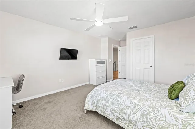 a bedroom with a bed and a ceiling fan