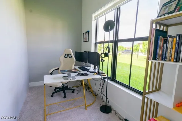 a view of a workspace with furniture and a window