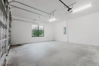 a view of a big room with windows and chandelier fan
