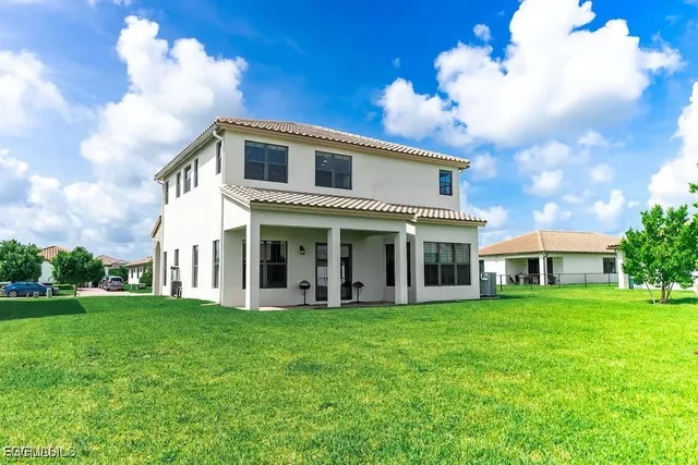 a front view of a house with garden and trees