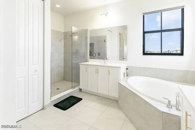 a bathroom with a tub sink shower and mirror
