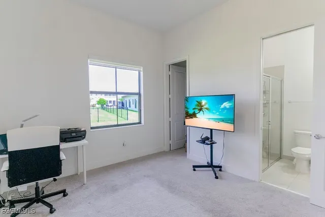 a view of a workspace with furniture and a window